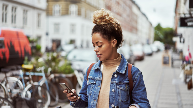 Woman texting while wearing a backpack 