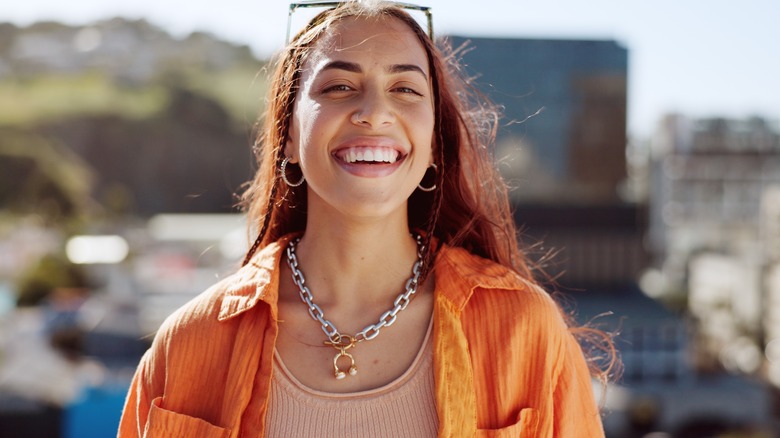 Laughing traveler wearing chunky jewelry