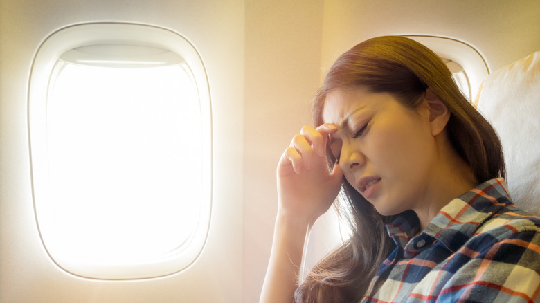 woman with headache on plane
