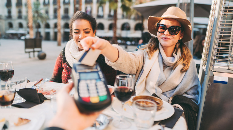 Women paying for meal with card