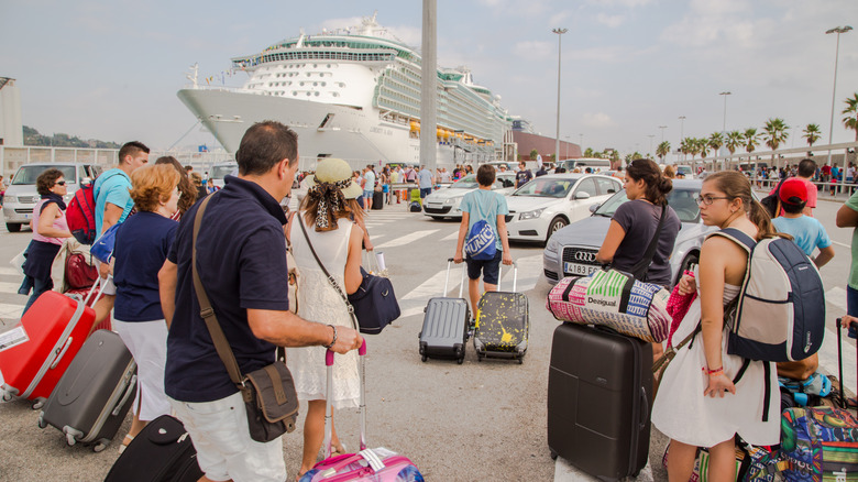 Travelers with suitcases near cruise