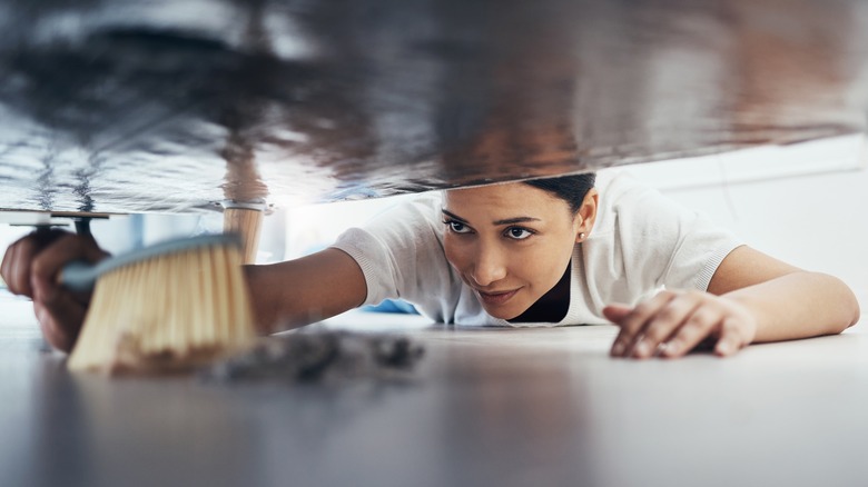 Woman cleaning under the bed