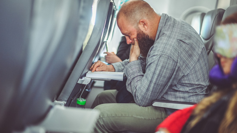 Man squeezed by seat recline