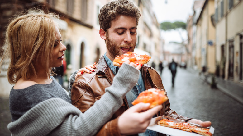 couple eating pizza in Italy