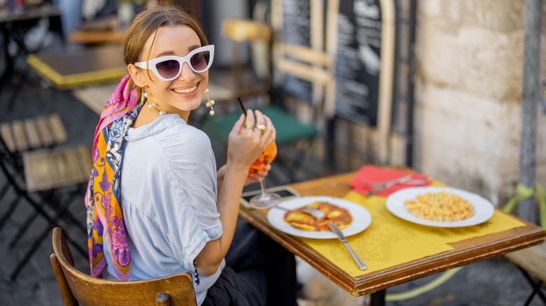 Woman eating pasta on a street in Rome