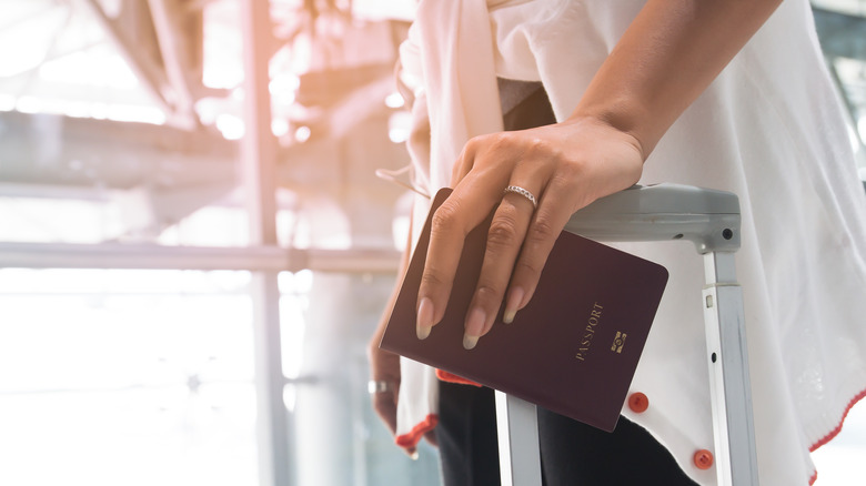 woman wearing ring holding passport