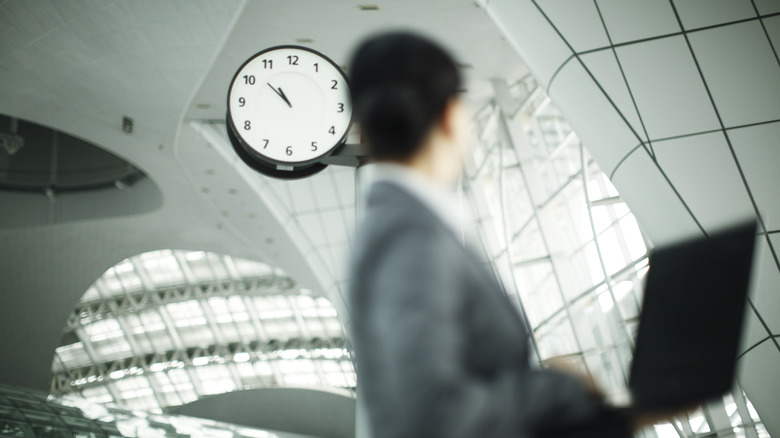 blured image of woman looking at clock on wall