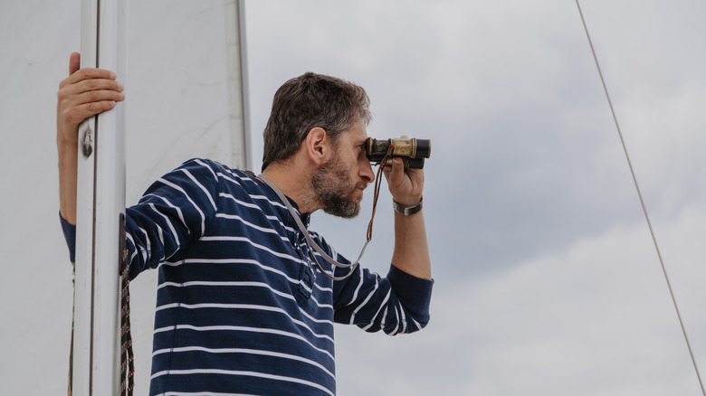 man leering with binoculars