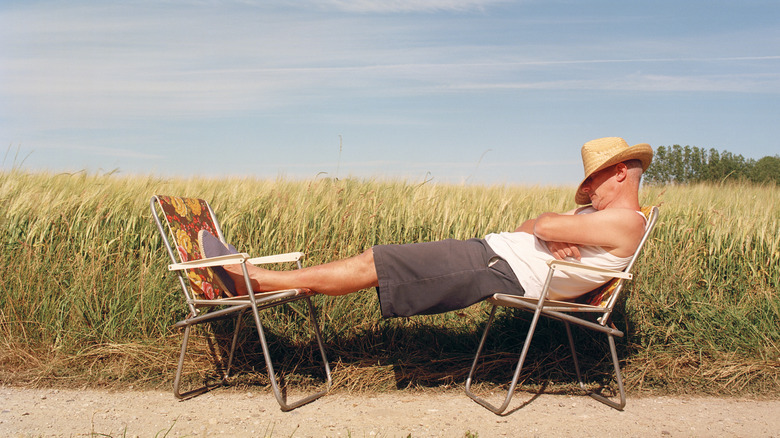 man sleeping outside wearing straw hat