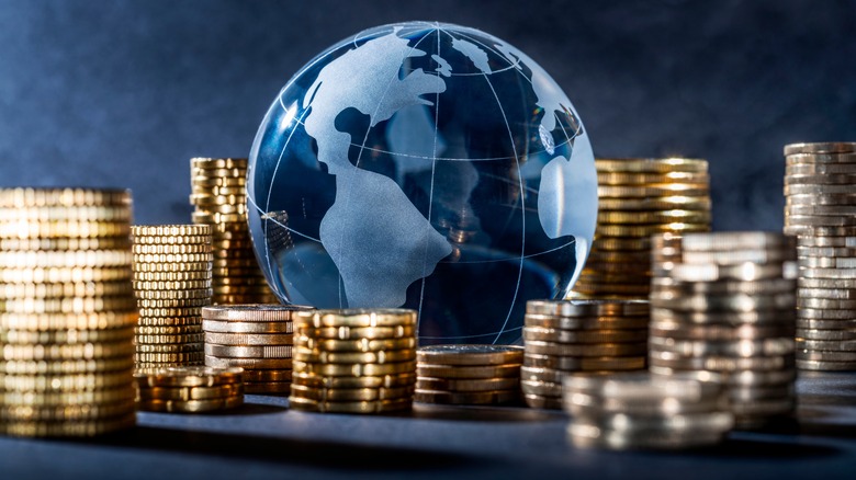 stacks of coins surround a globe