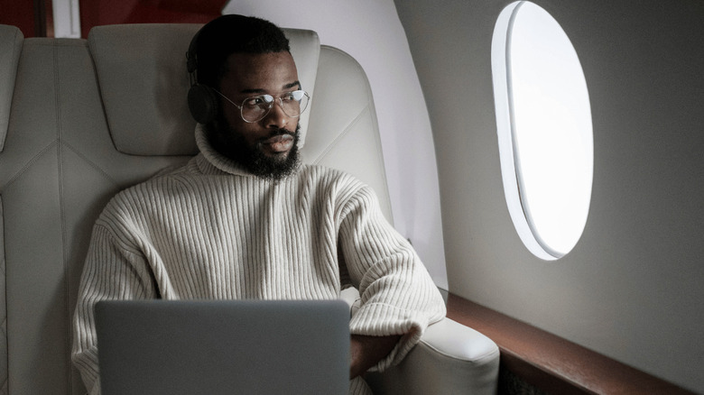 man with laptop on plane