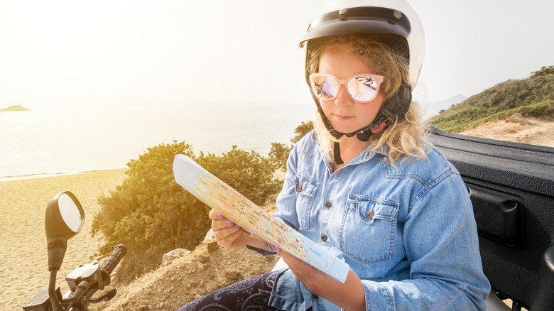 Woman on ATV reading map