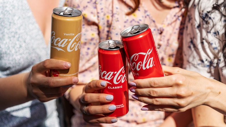 people holding coca-cola