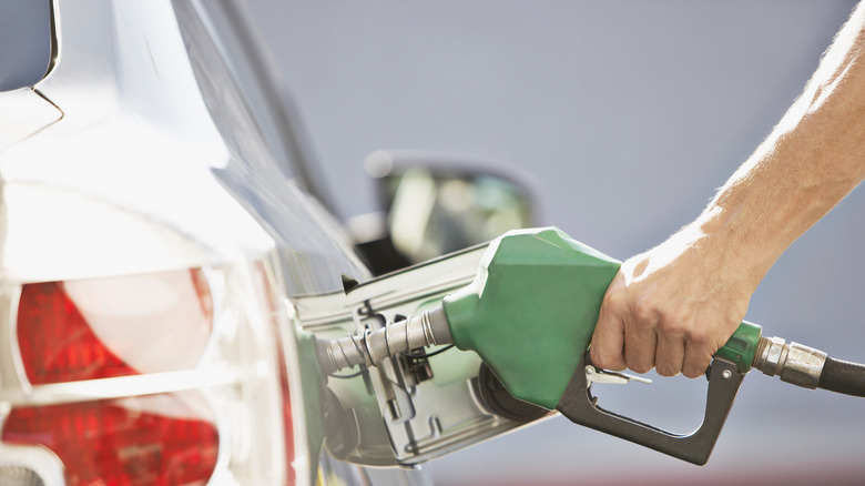 Person putting gas in car