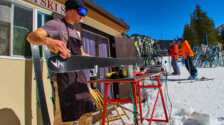 man repairing ski at alta