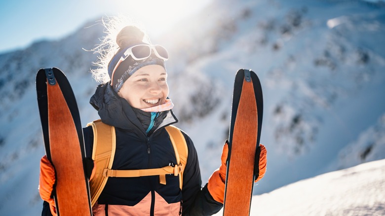 Woman holding orange skis