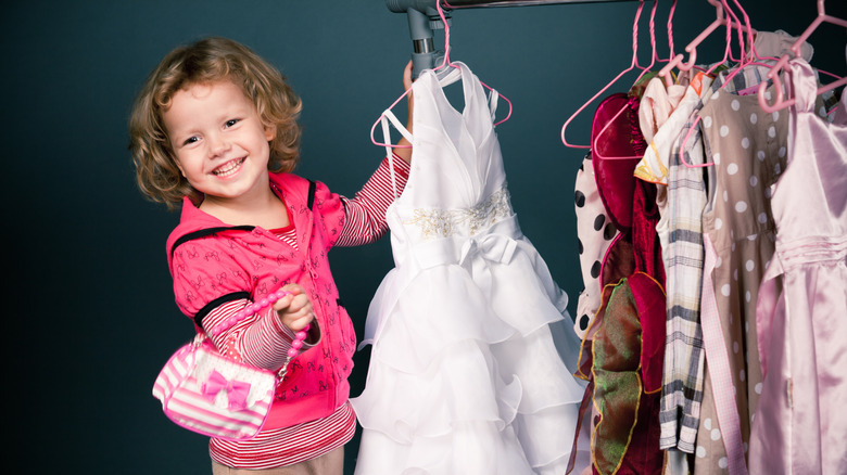 little girl trying on dresses