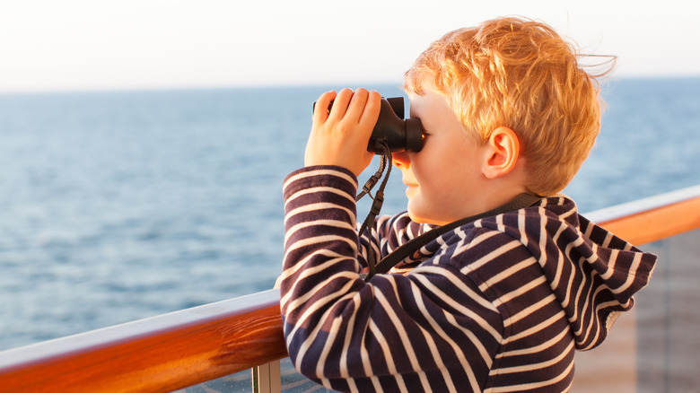 Boy using binoculars on cruise